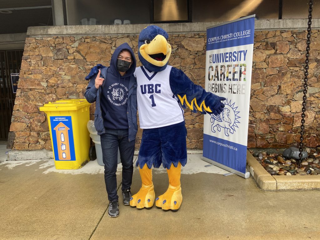 A Student Recruiter poses with the UBC mascot at a UBC Thunderbirds football game.
