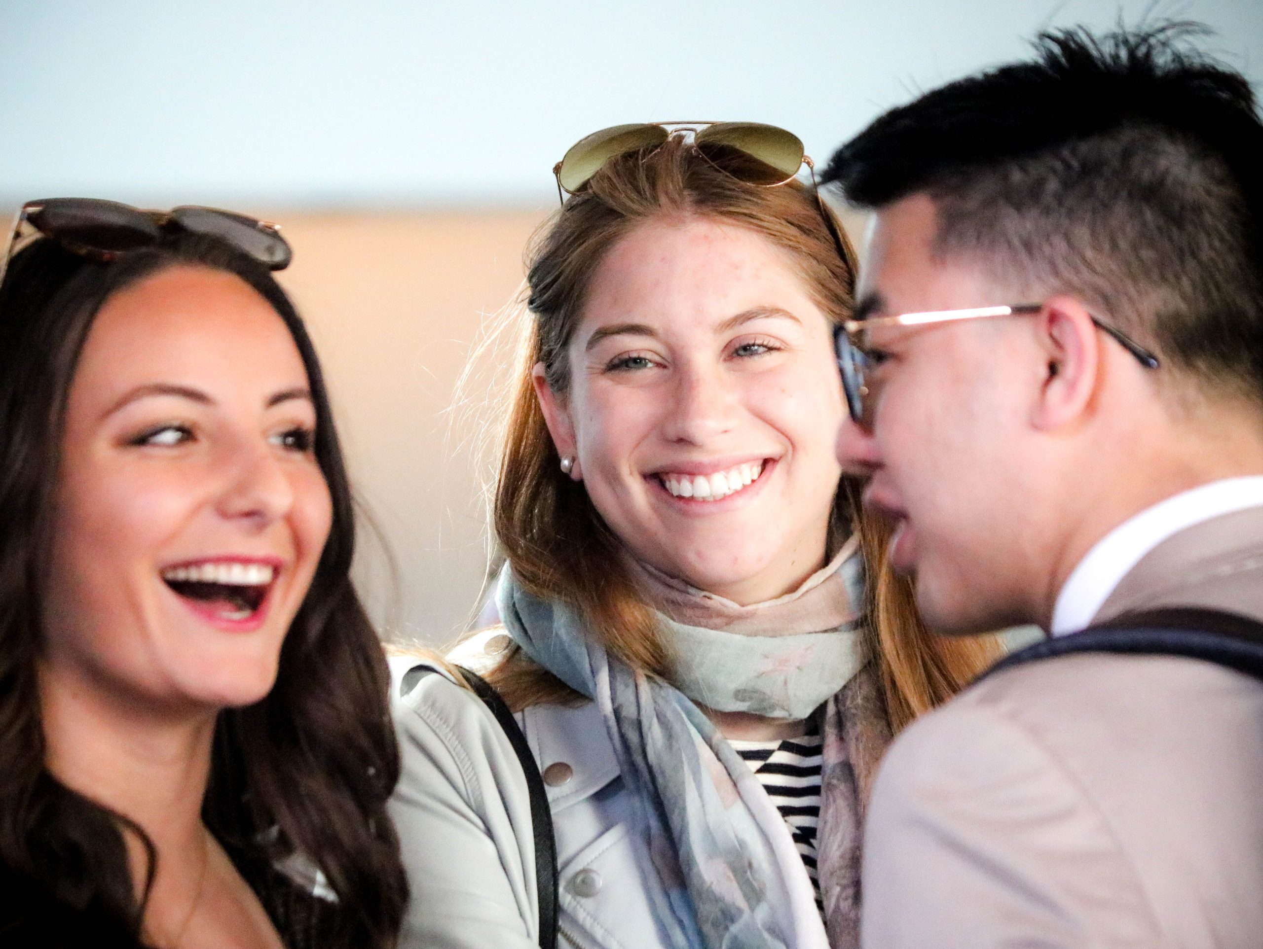 Three alumni laugh together at a Corpus Christi College event.